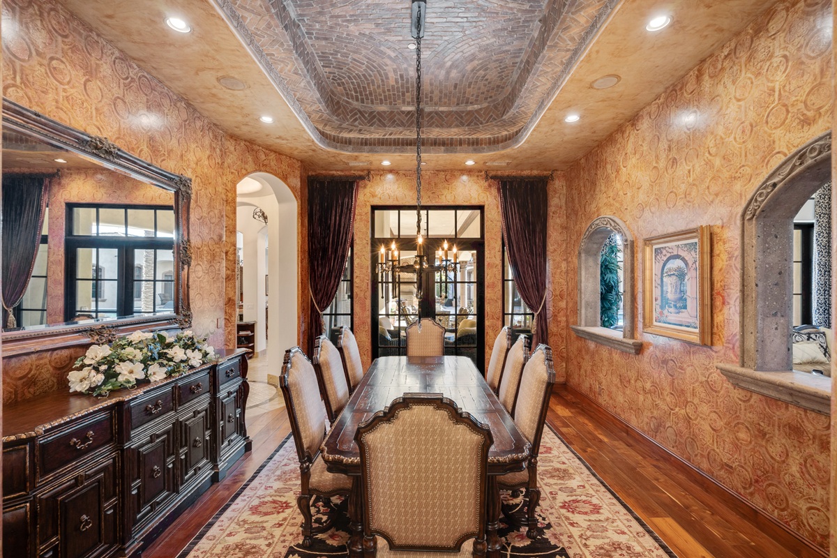 Ornate luxury dining room with rich wood furnishings and a brick ceiling.