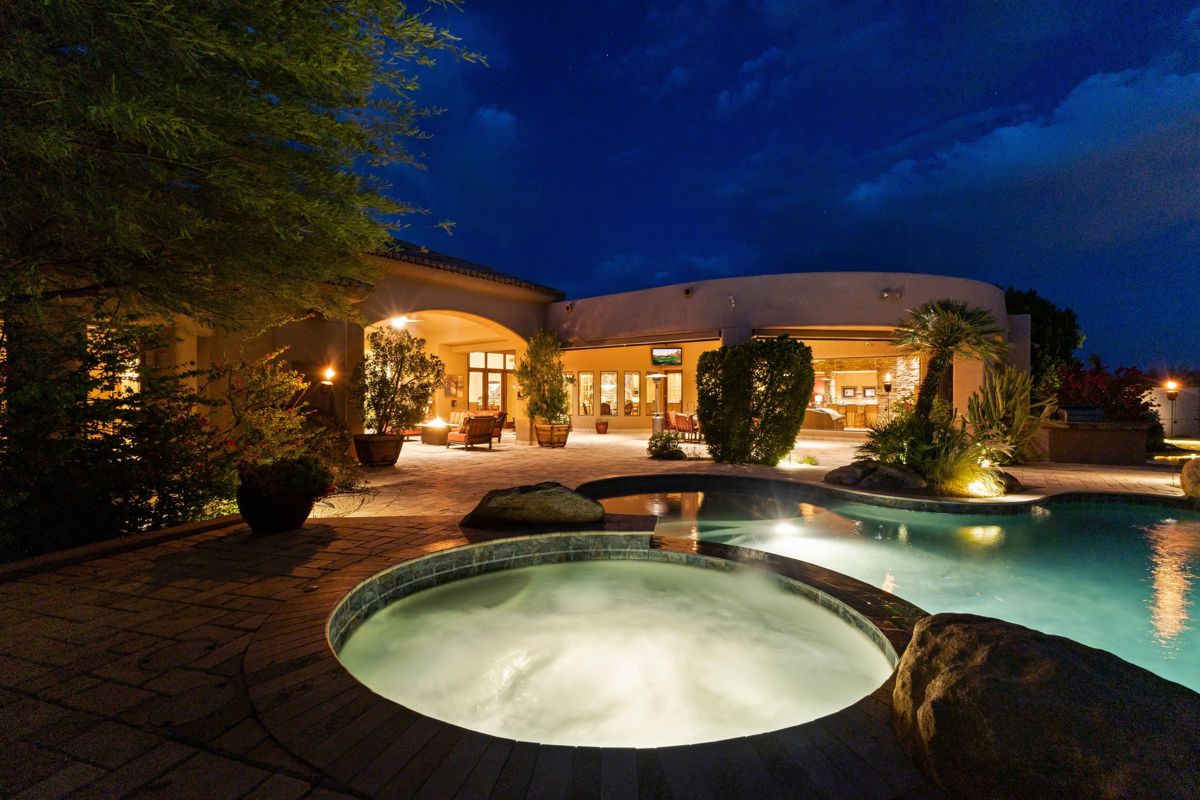 Scottsdale luxury home with a pool and spa beneath a colorful sunset sky.