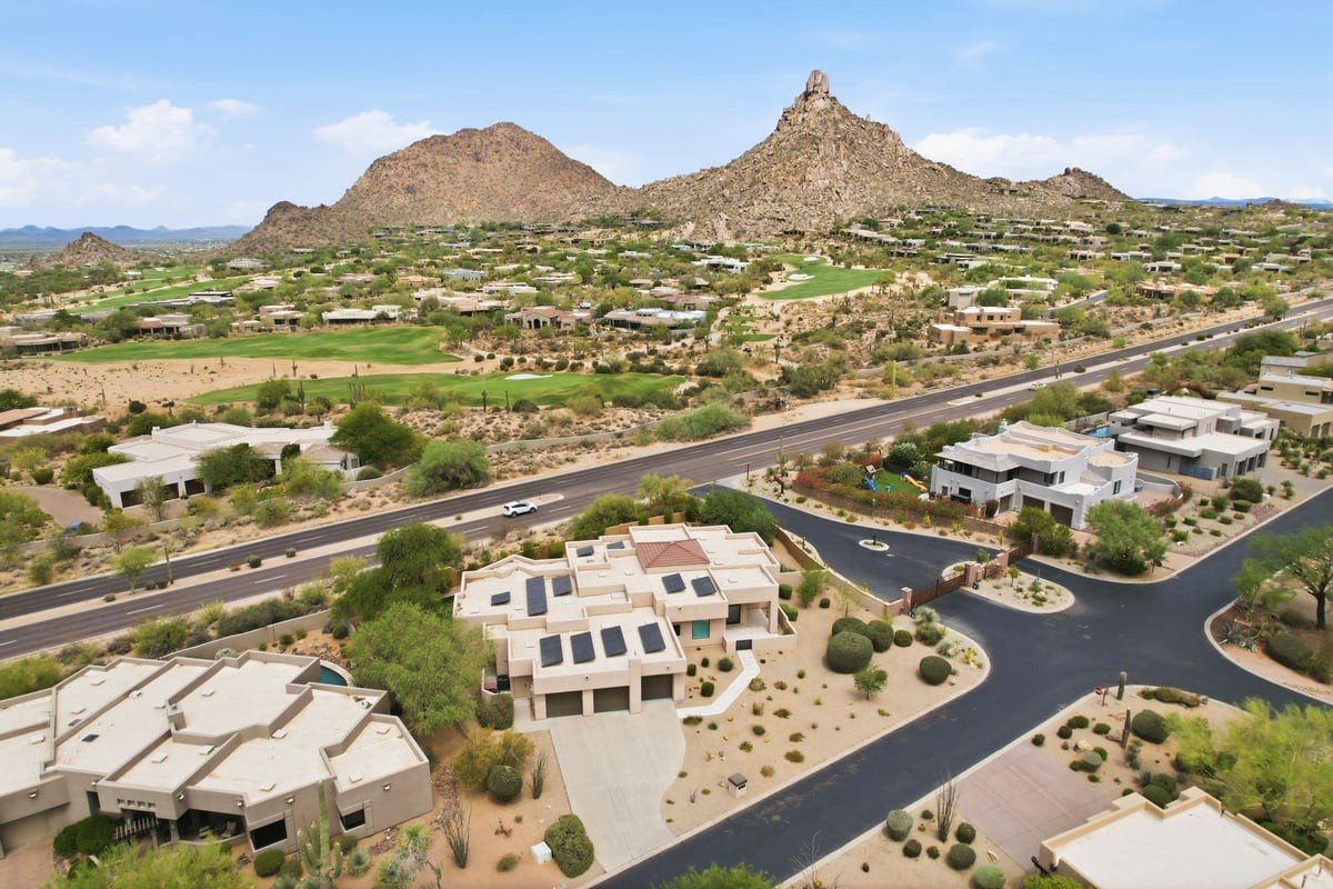 Aerial view of a luxury Scottsdale golf community surrounded by desert mountains.