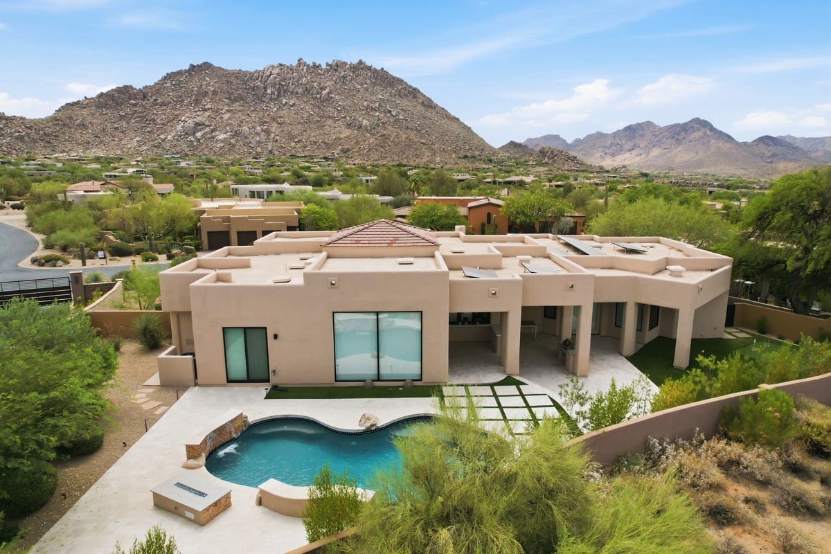 Aerial view of a luxury Scottsdale home with a pool and mountain backdrop.