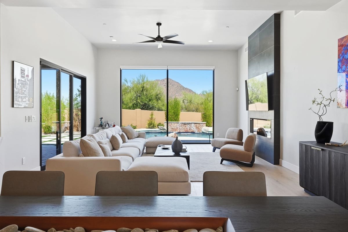 A photo of a modern Scottsdale great room overlooking a pool and desert landscape.
