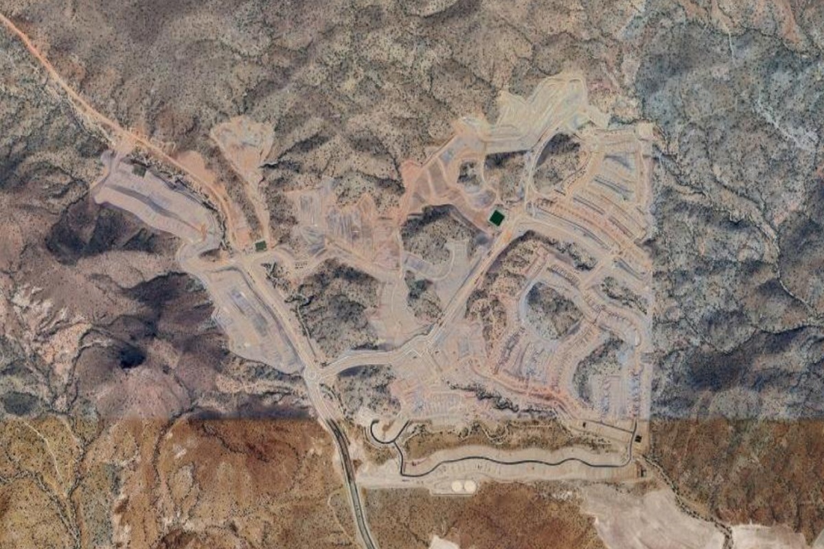 Aerial photo of the Saddleback development in Peoria, showing graded homesites, winding roads, and construction areas surrounded by rugged desert hills.
