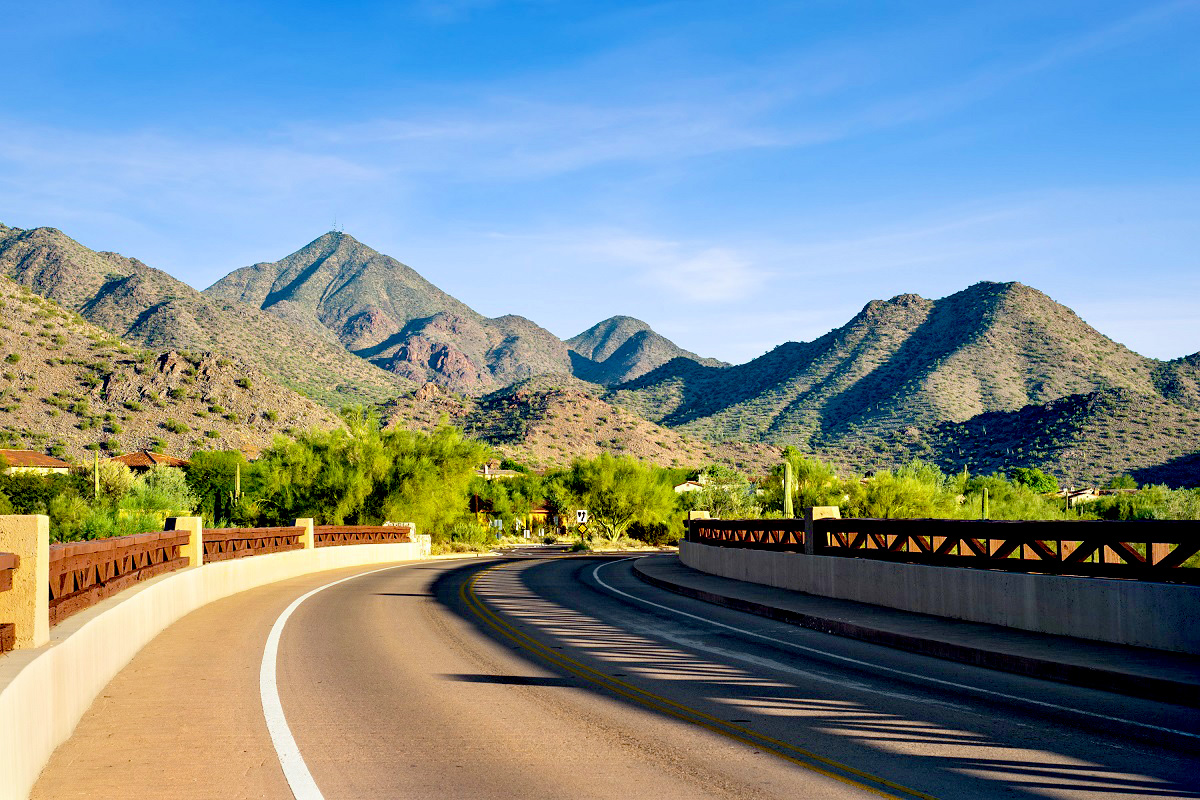 Scenic road through Scottsdale's DC Ranch area, surrounded by Sonoran Desert vegetation and the McDowell Mountains.