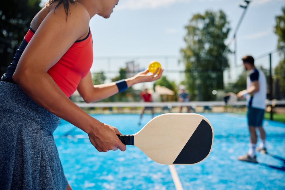 female pickleball player serving