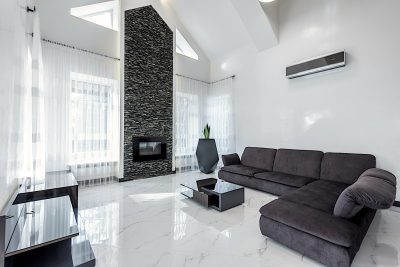 Picture of a large, tiled living room with a mini-split on the wall.