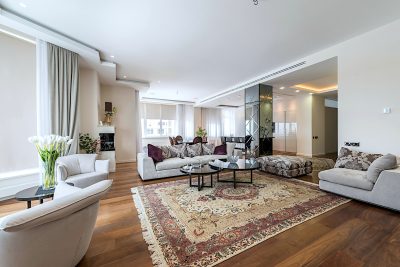 Picture of a large living room with hardwood floors and an area rug.