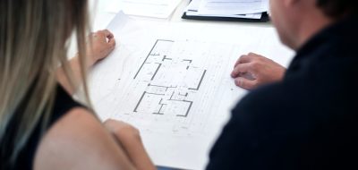 Picture of two people looking at a floorplan.