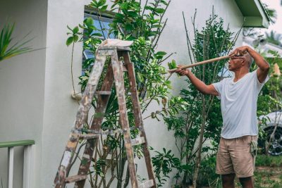 Man painting a stucco house.