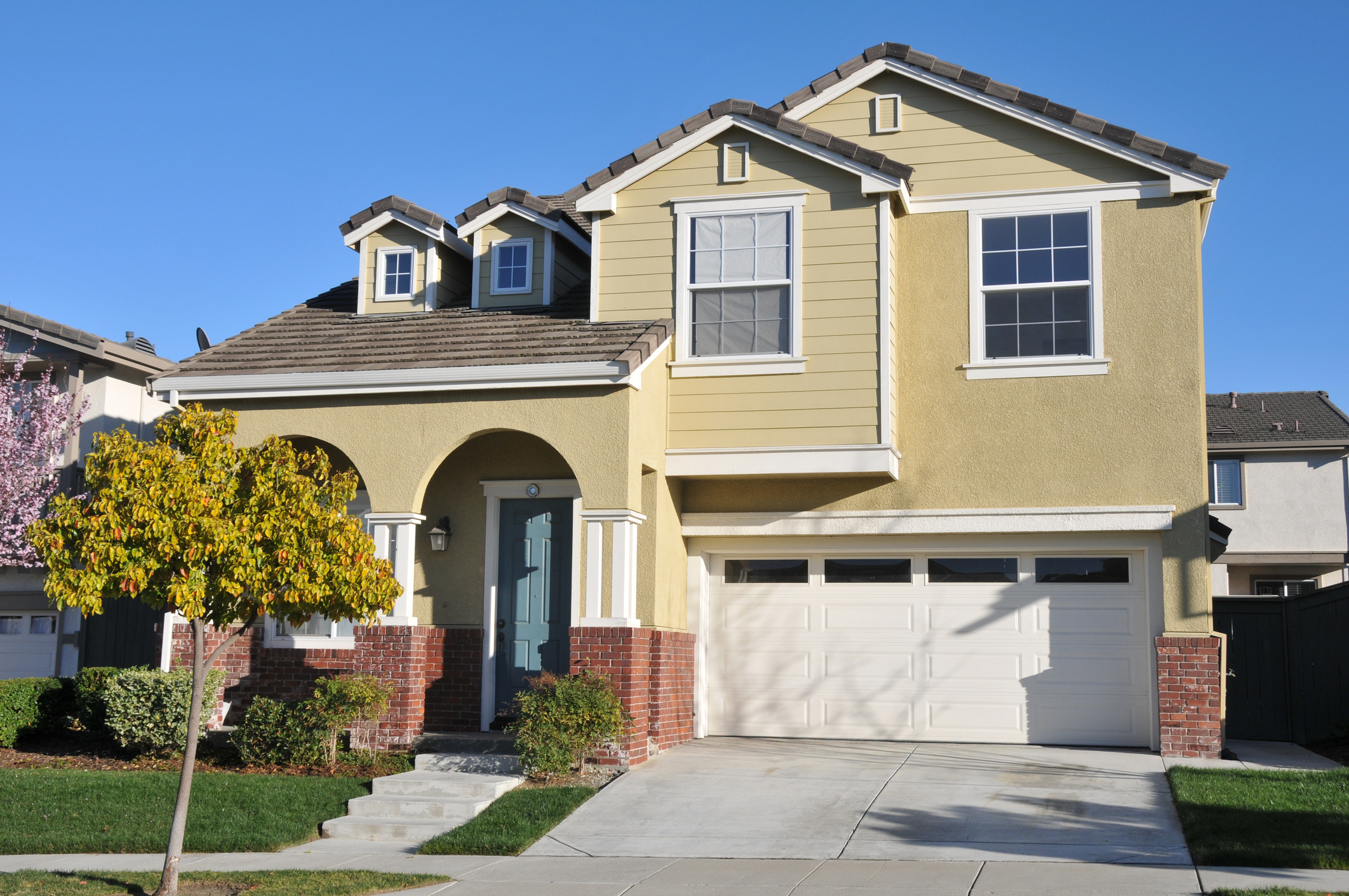Single family house with two levels and a short driveway.