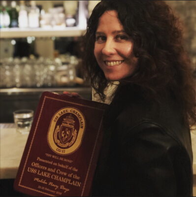 Danielle Dutcher accepting a Navy Day recognition plaque on behalf of the Malibu Chamber of Commerce.