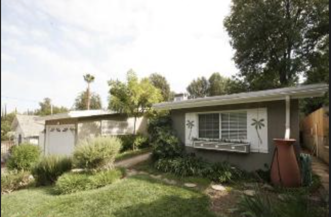 Single-story home with landscaped yard and detached garage in Woodland Hills, CA