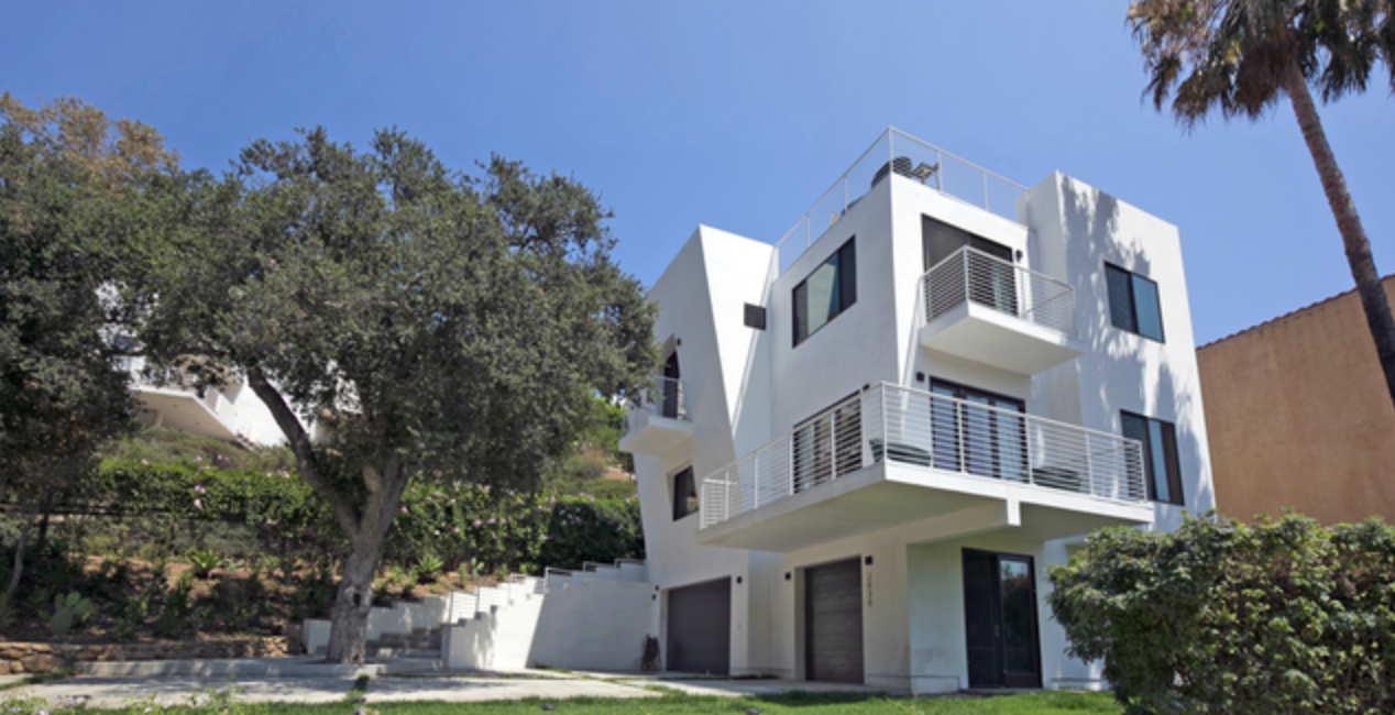 Modern three-story home with balconies and hillside landscaping in Malibu, CA