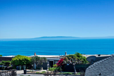 A bright coastal view from Sunset Mesa in Malibu showing the Pacific Ocean and Catalina Island on the horizon, highlighting the peaceful oceanfront lifestyle.