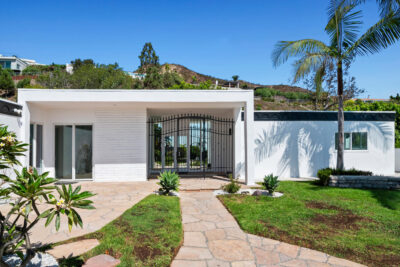A front exterior view of 18073 Sandy Cape Dr in Pacific Palisades, a modern Sunset Mesa home for sale near Malibu with gated entry and ocean-view location.