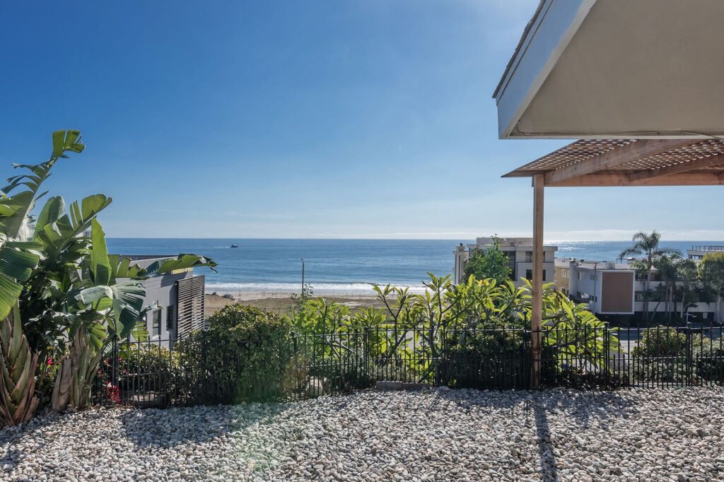 Ocean view from the long-term Malibu rental overlooking Carbon Beach, coastal homes, and blue water under a clear sky.