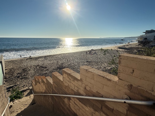 Beach access walkway on Malibu Road leading down to the sand with ocean views
