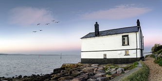Panorama of an old house on the beach at Lepe in the New Forest.