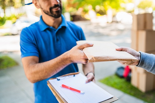 Portrait of a delivery man making home delivery to his customer. Delivery and shipping concept.