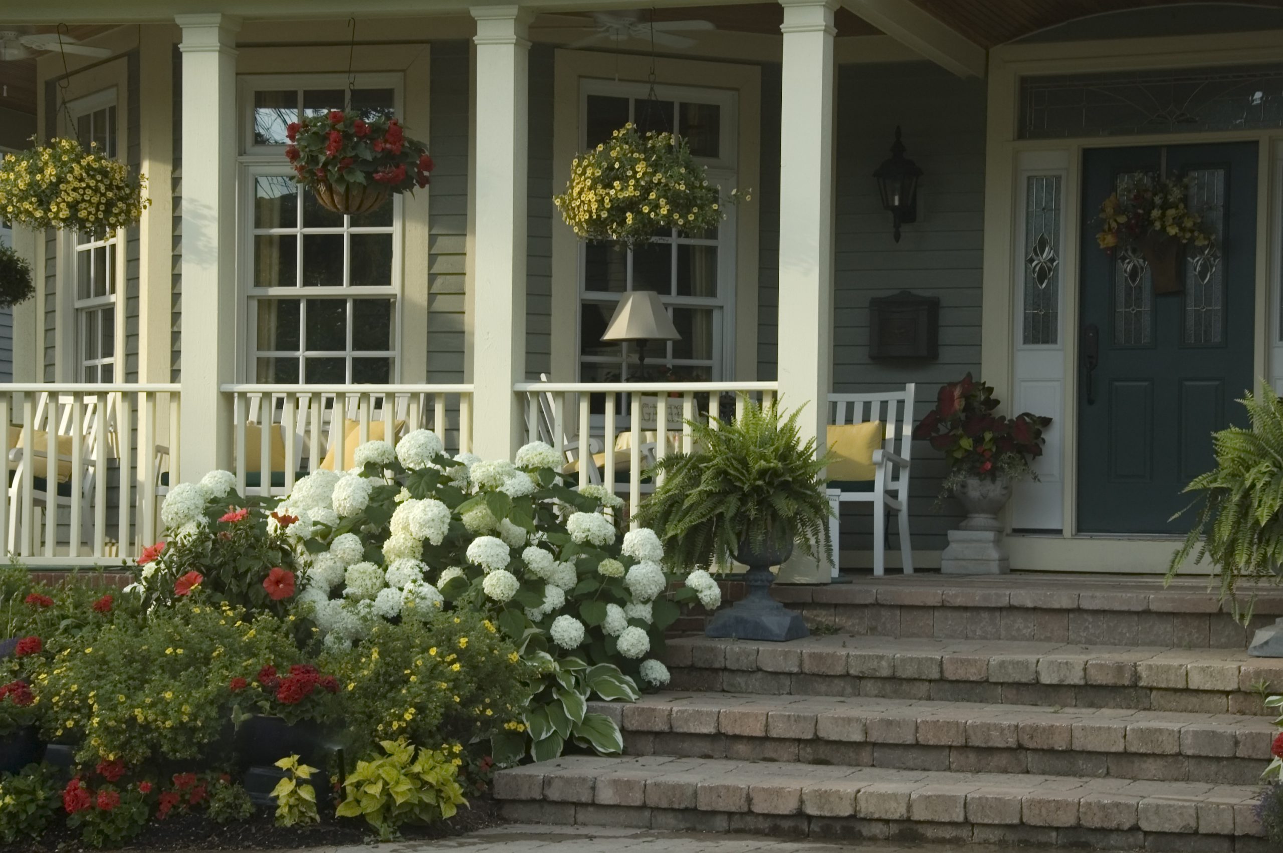 Well-maintained home exterior with manicured lawn, freshly painted front door, and clean driveway, showing strong curb appeal for selling a home.