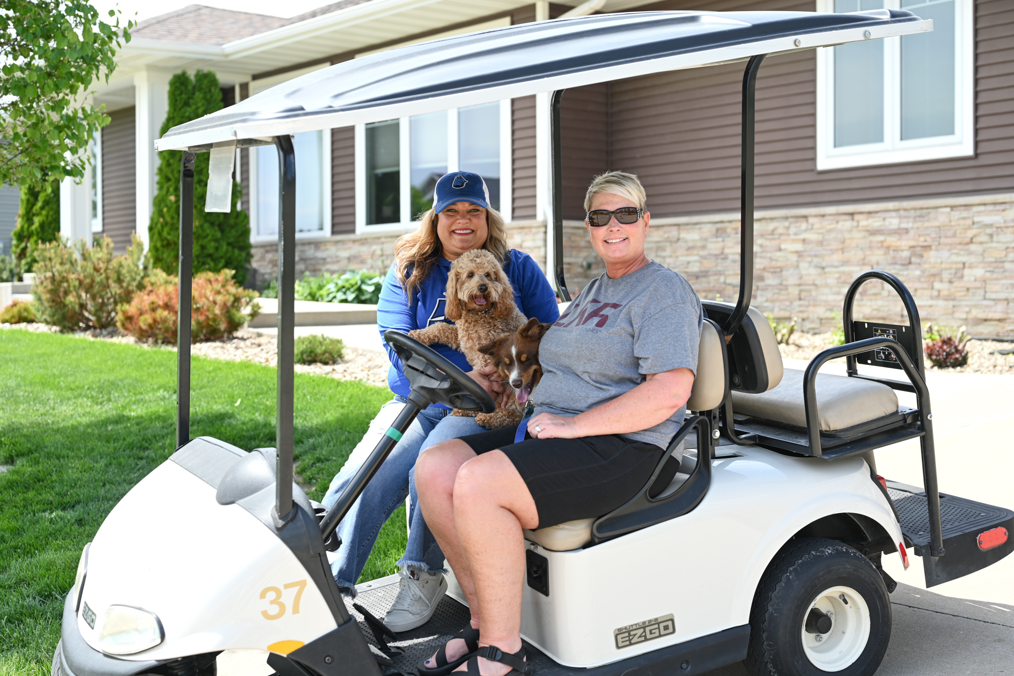 Monica Hayes and Tracy Reiten enjoy a golf cart ride in Tiffin, Iowa