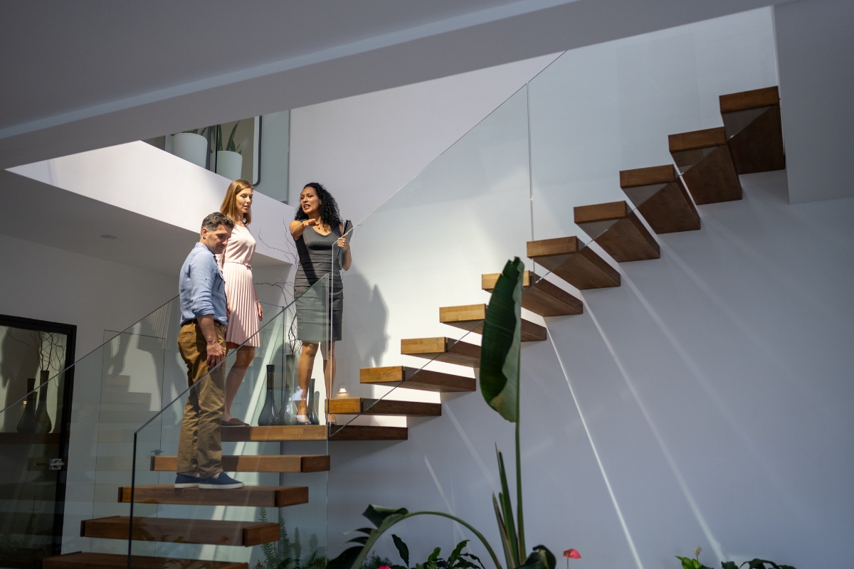 Real estate agent and clients walking upstairs