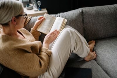 Homeowner relaxing on a couch while reading about mortgage rate trends.