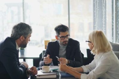 Real estate agent meeting with clients to discuss home contract strategies.