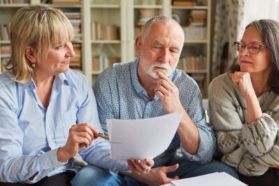 Older couple reviewing home sale documents while planning to downsize and buy their next house with cash in the DMV area.