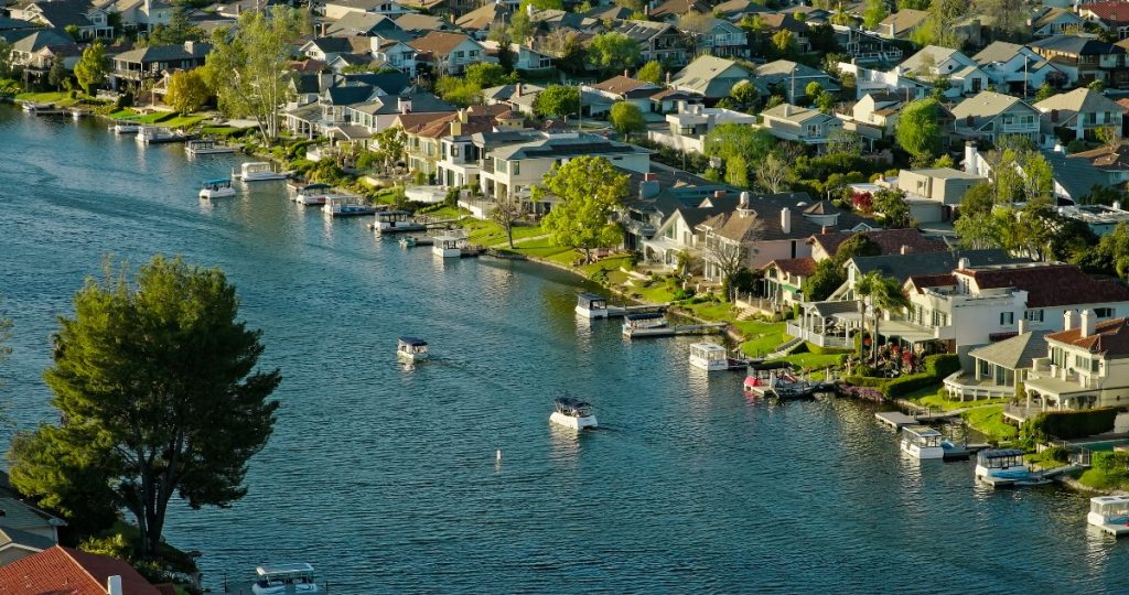 Boats Passing Houses in Westlake Village, CA at Sunset - High Angle Drone Shot