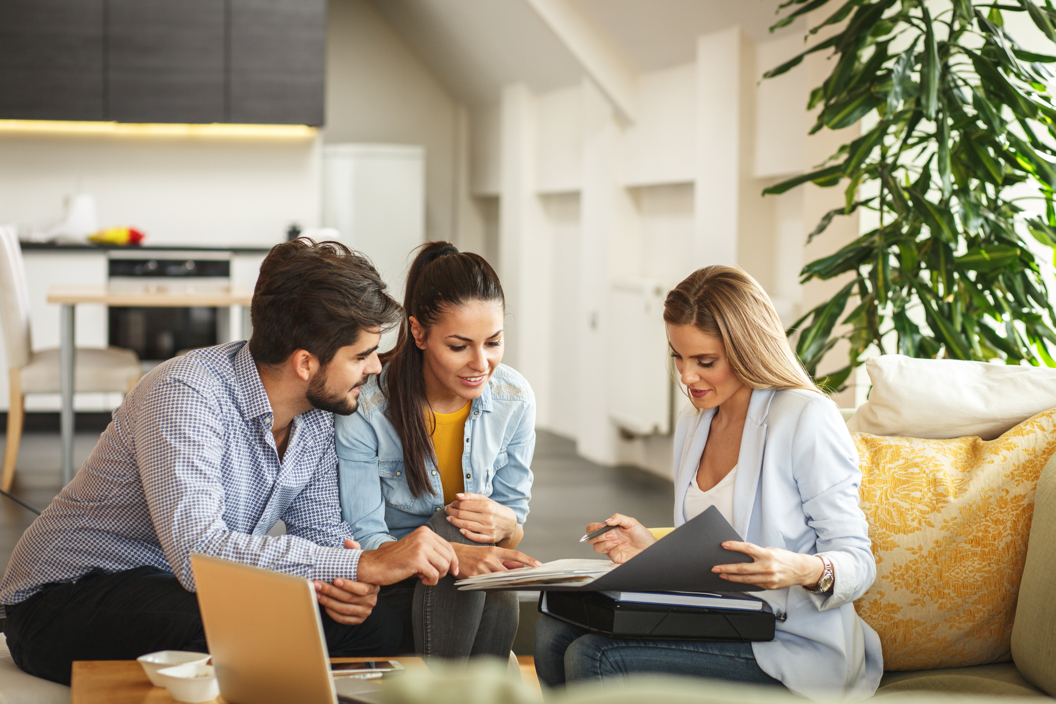 A real estate agent speaking with clients about selling a luxury home
